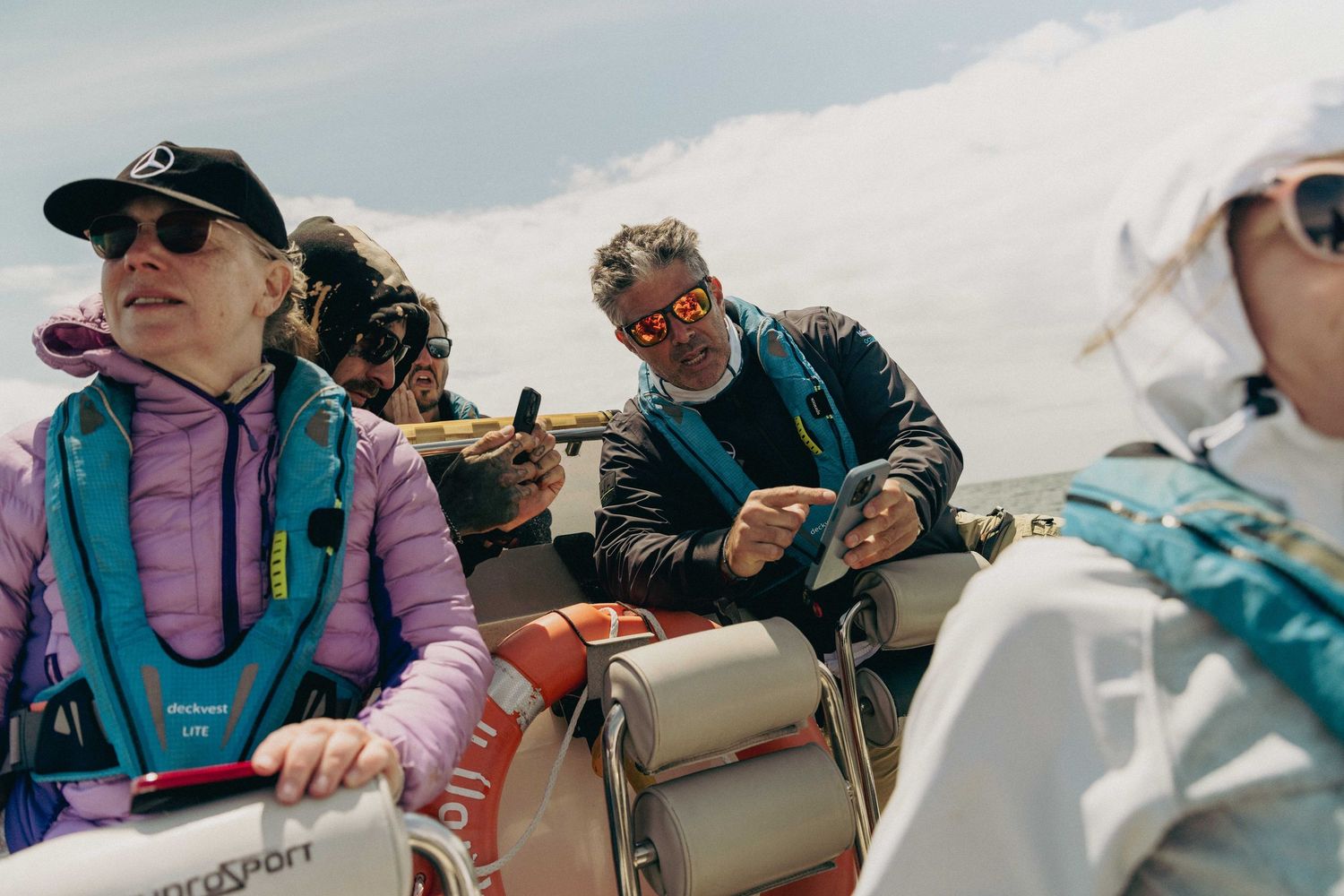 Group of people enjoying a sunny outdoor adventure wearing casual outdoor gear and sunglasses.