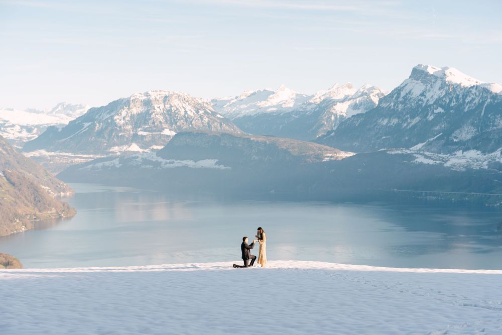 A scenic mountain landscape with snow-capped peaks reflected in a tranquil lake during golden hour.