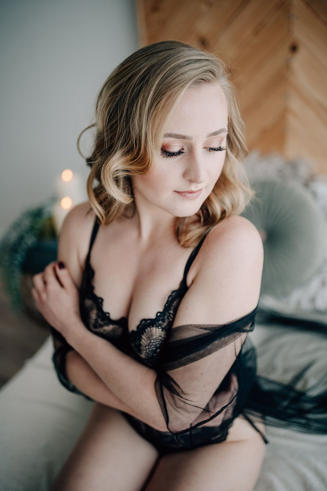 Soft boudoir portrait in black lingerie with romantic lighting and wooden wall background. Boudoirfotografie Rhein Main Frankfurt