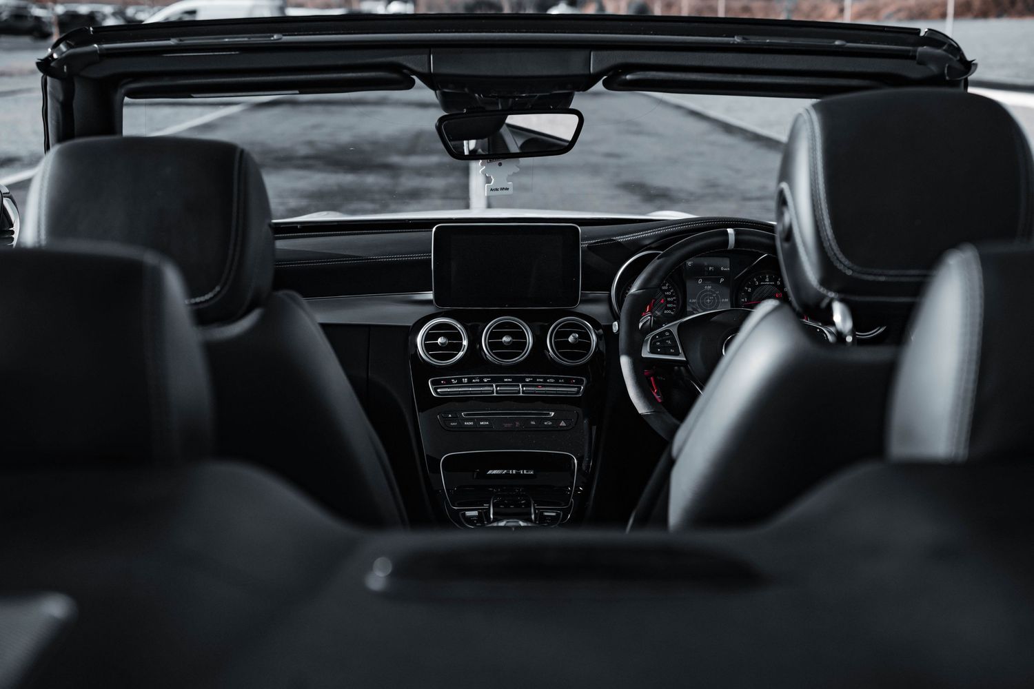 Interior dashboard view of a luxury car showing modern controls and leather seats.