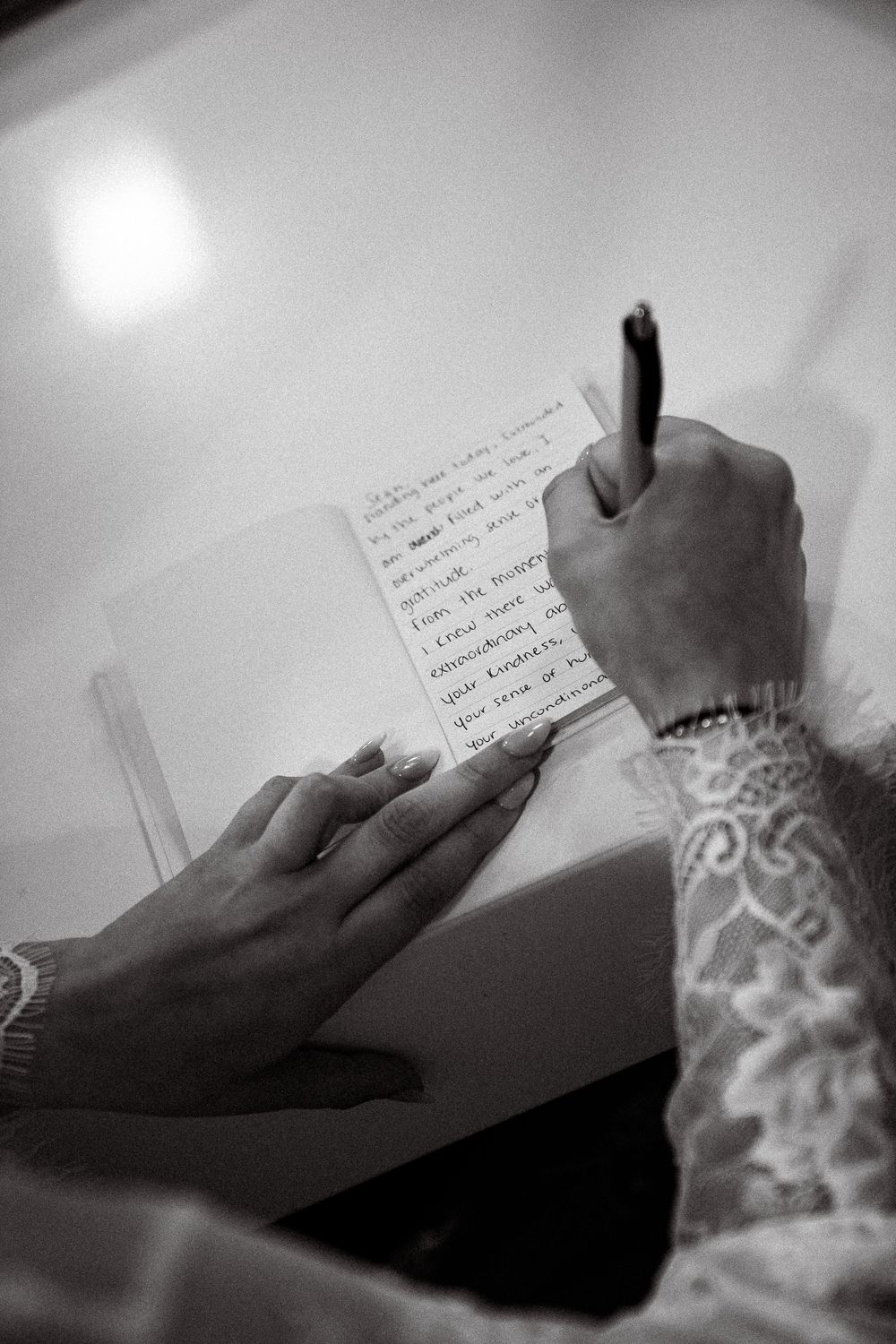 Black and white photo sequence showing hands writing in a notebook against a white background.