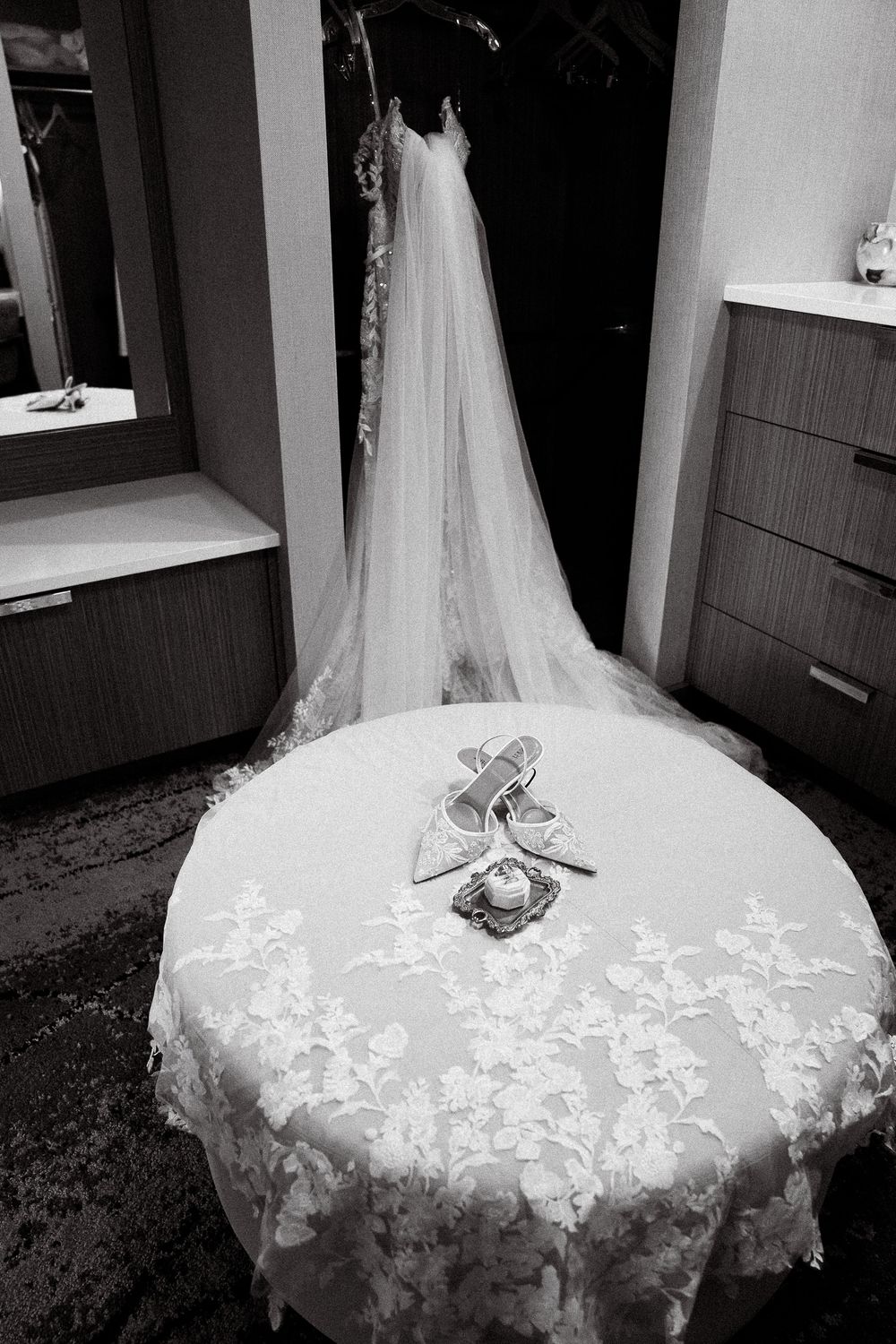 A black and white collage of wedding dress details showing intricate lace patterns and flowing tulle fabric.