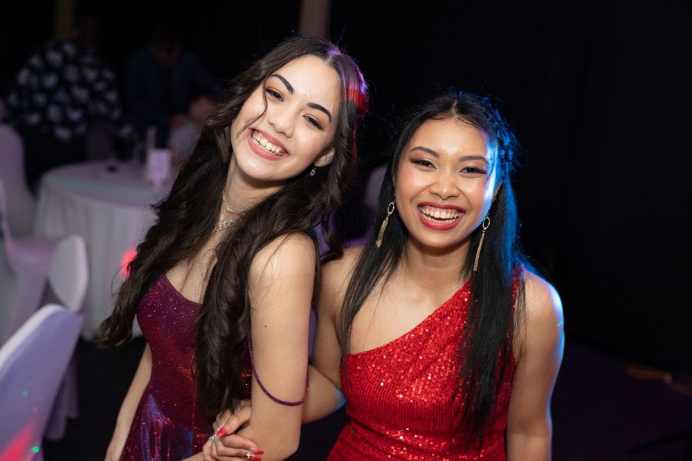 Sydney Event Photography - Two friends in formal dresses smiling together at an evening celebration.