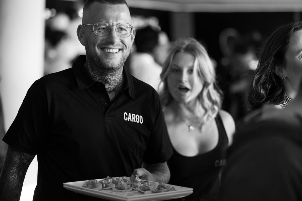 Sydney Event Photography - Server in black uniform carries appetizers on a tray during an evening event.