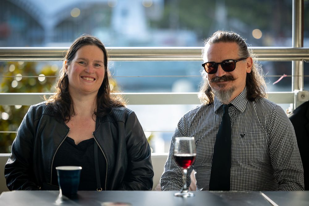 Sydney Event Photography - Couple enjoying drinks together at restaurant table with window view.