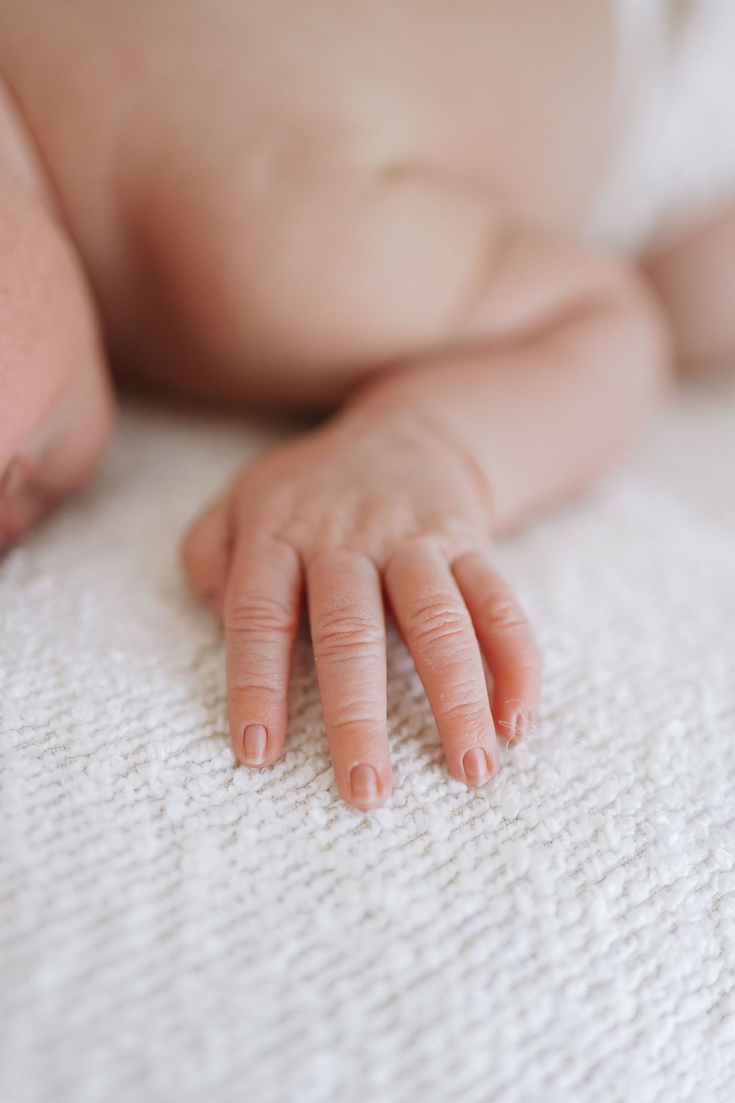 Black and white photo of tender moment between newborn and caregiver.