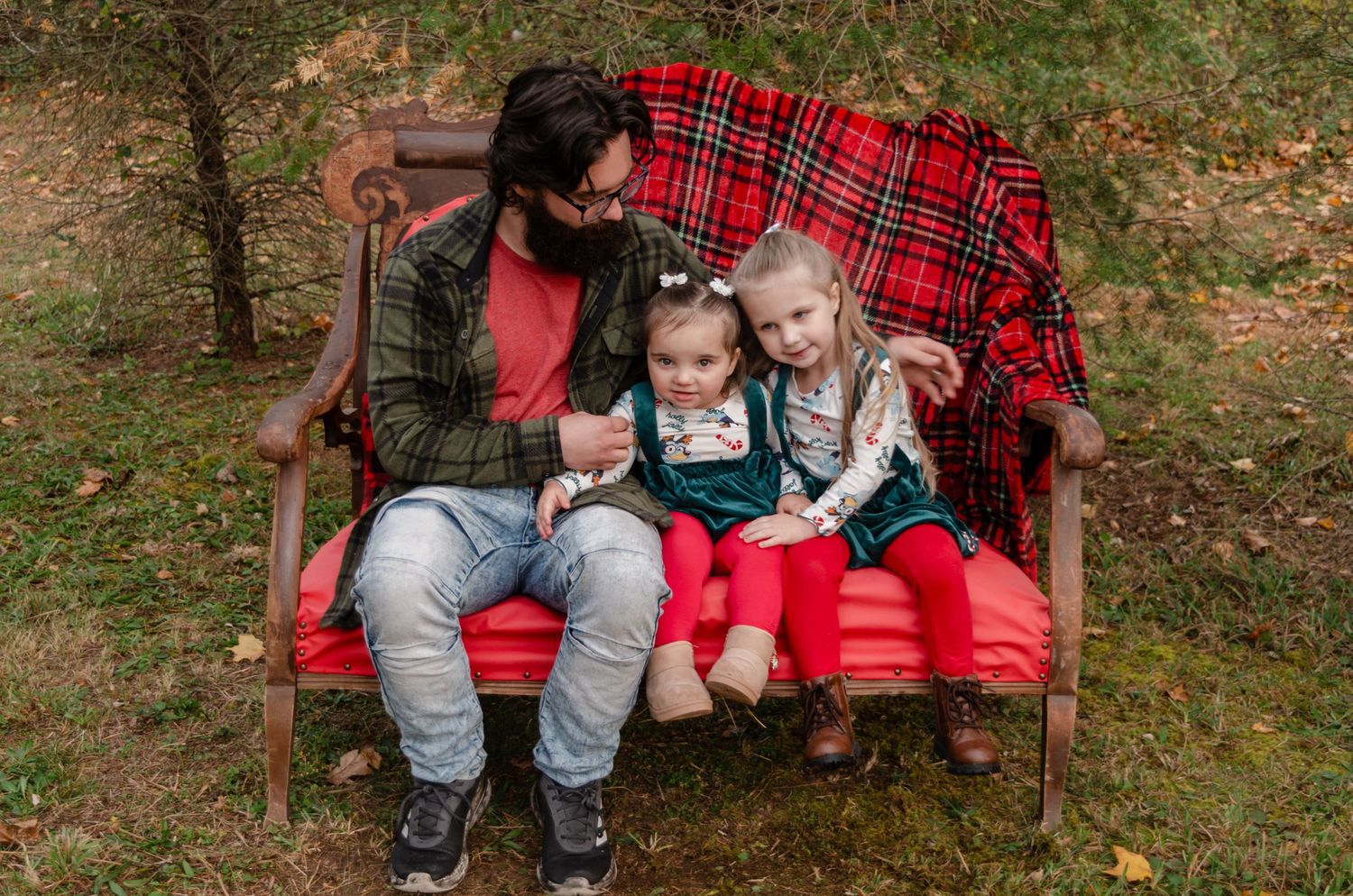 Toddler in plaid shirt at a festive hot cocoa bar stand decorated with holiday garland and bunting.