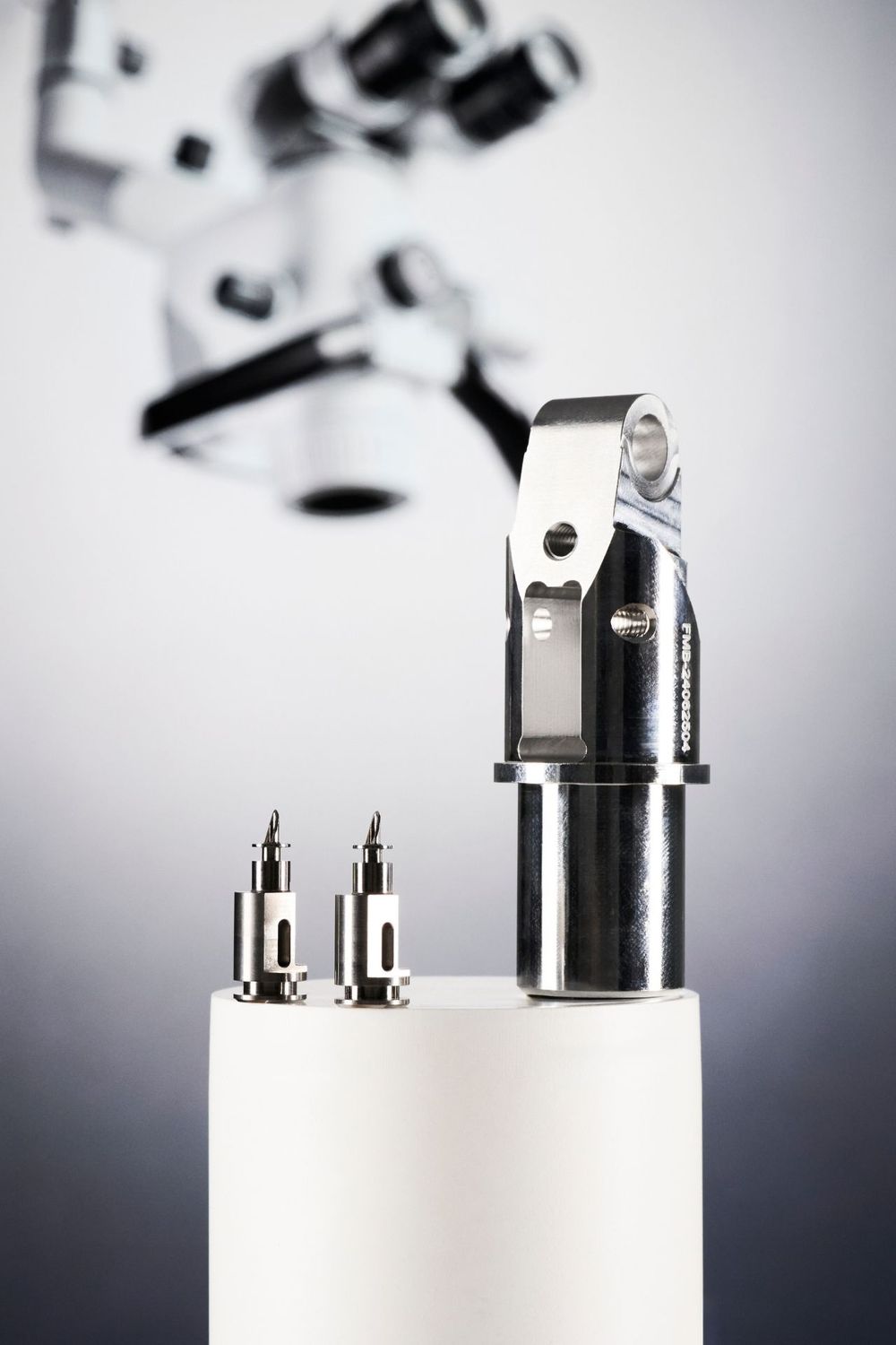 Close-up of precision metal mechanical parts and connectors on white surface with blurred background.