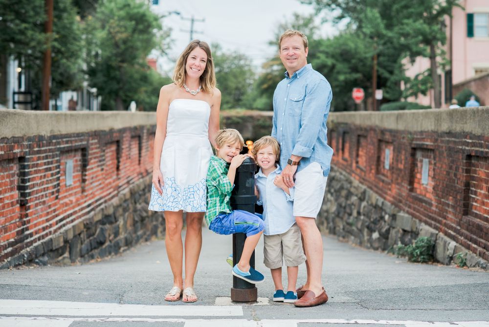 Family portrait session on a brick-paved pathway surrounded by greenery.
