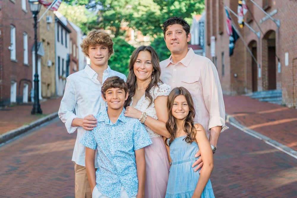 Family walking together along a historic brick-lined street.