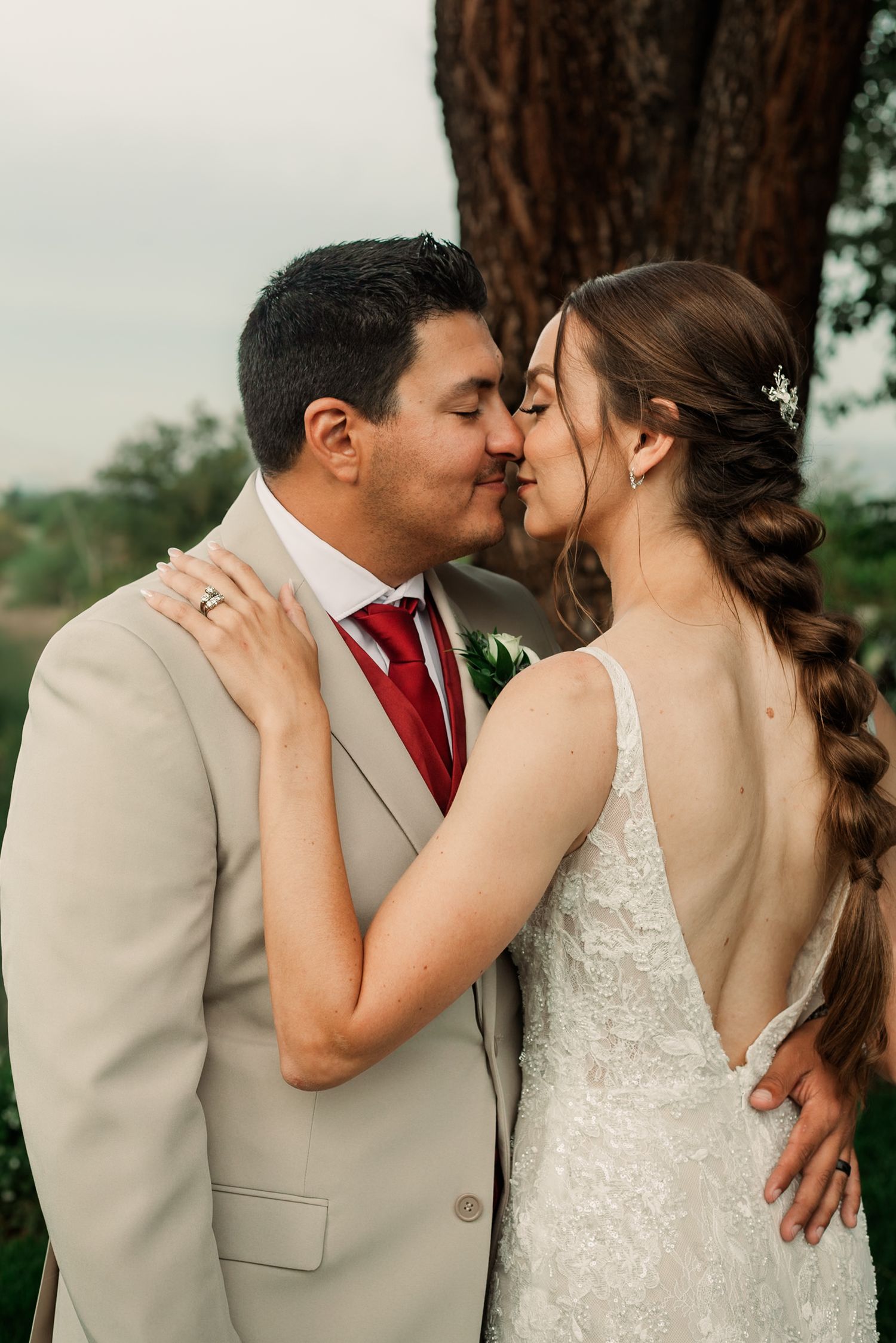 A romantic wedding couple shares intimate kisses in a series of outdoor portraits wearing beige and white attire.