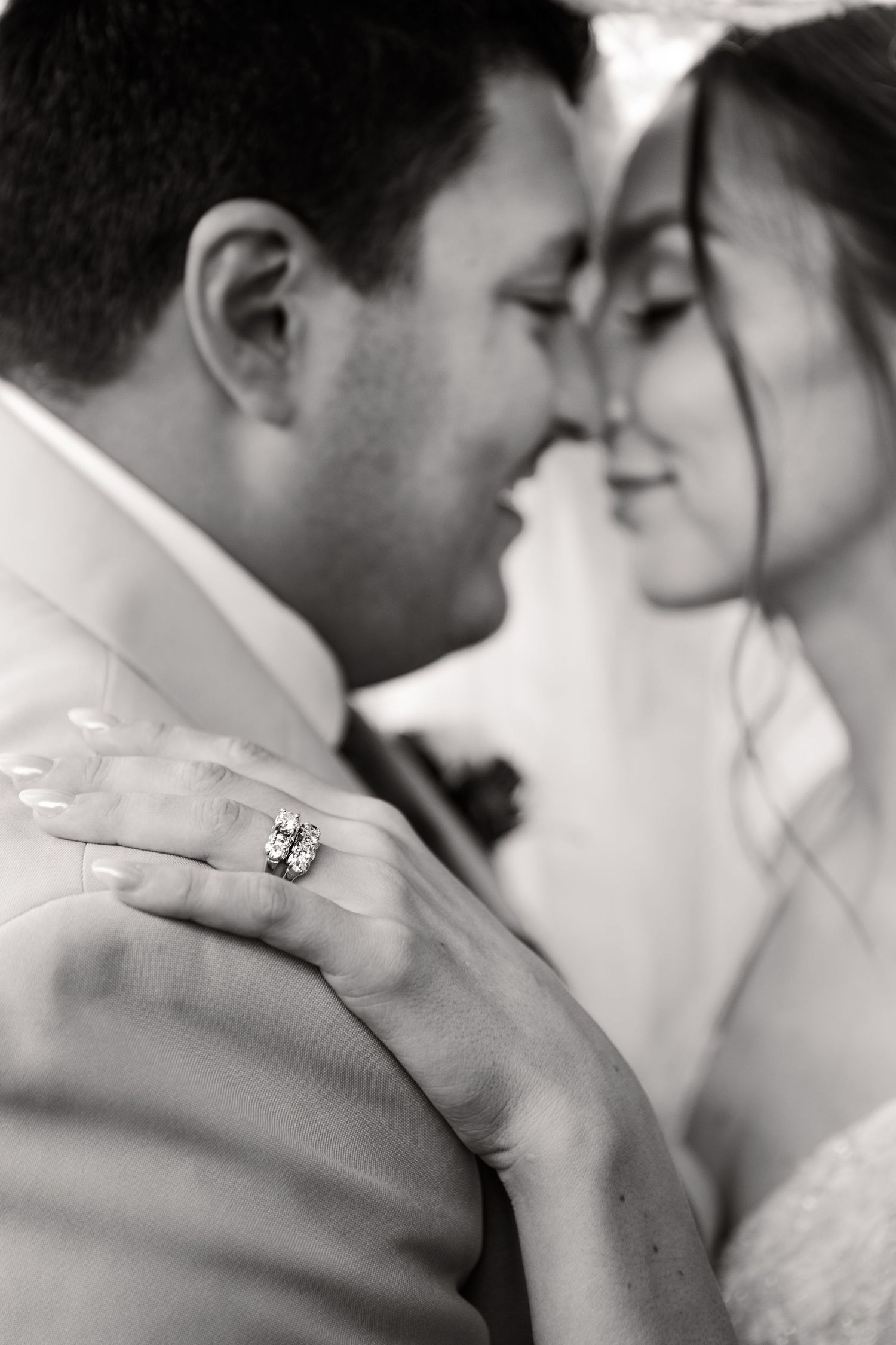 A series of intimate black and white wedding photos showing romantic close-up moments between newlyweds.