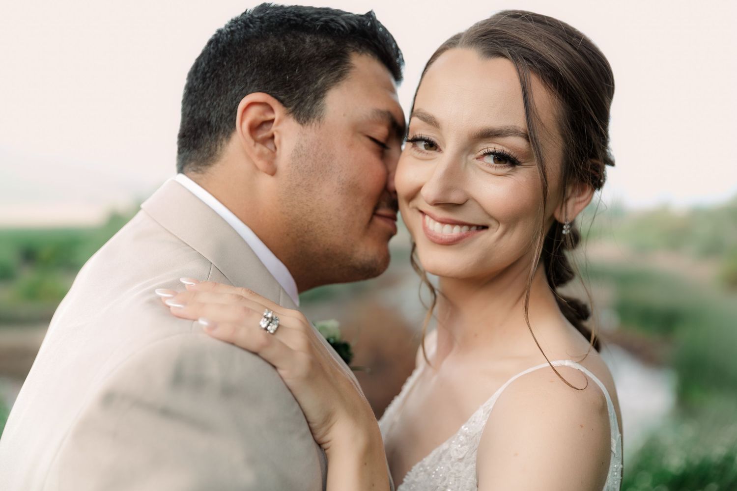 A romantic couple shares intimate moments in a wedding photo series set against a natural outdoor backdrop.