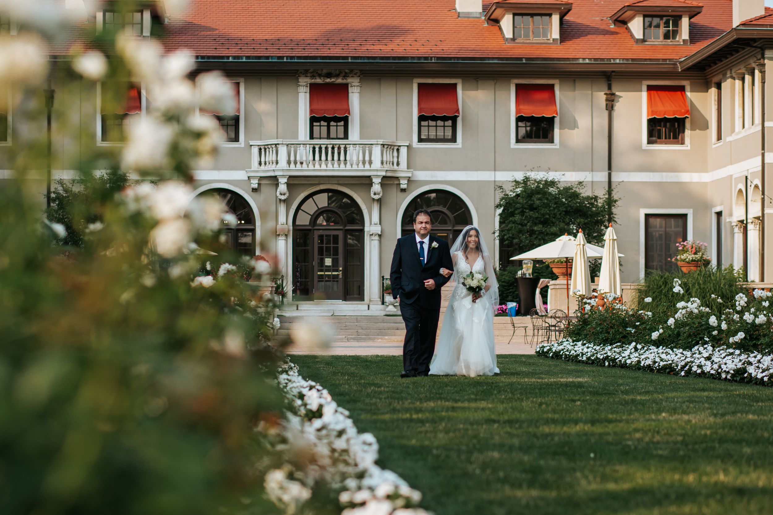 A series of outdoor wedding venue photos showing a white mansion with red roof and elegant garden settings at sunset.