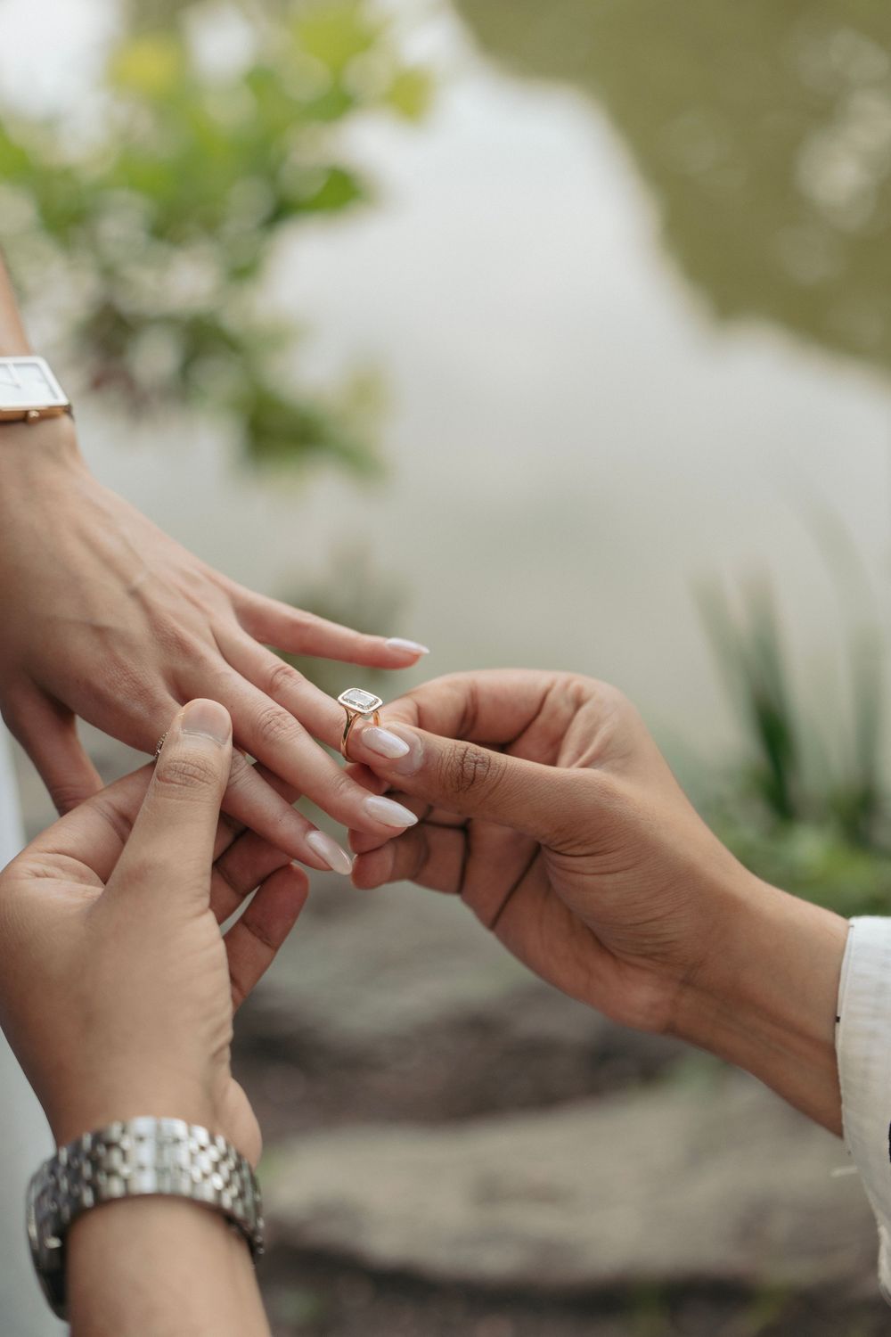 Close-up sequence of placing an engagement ring on a finger.