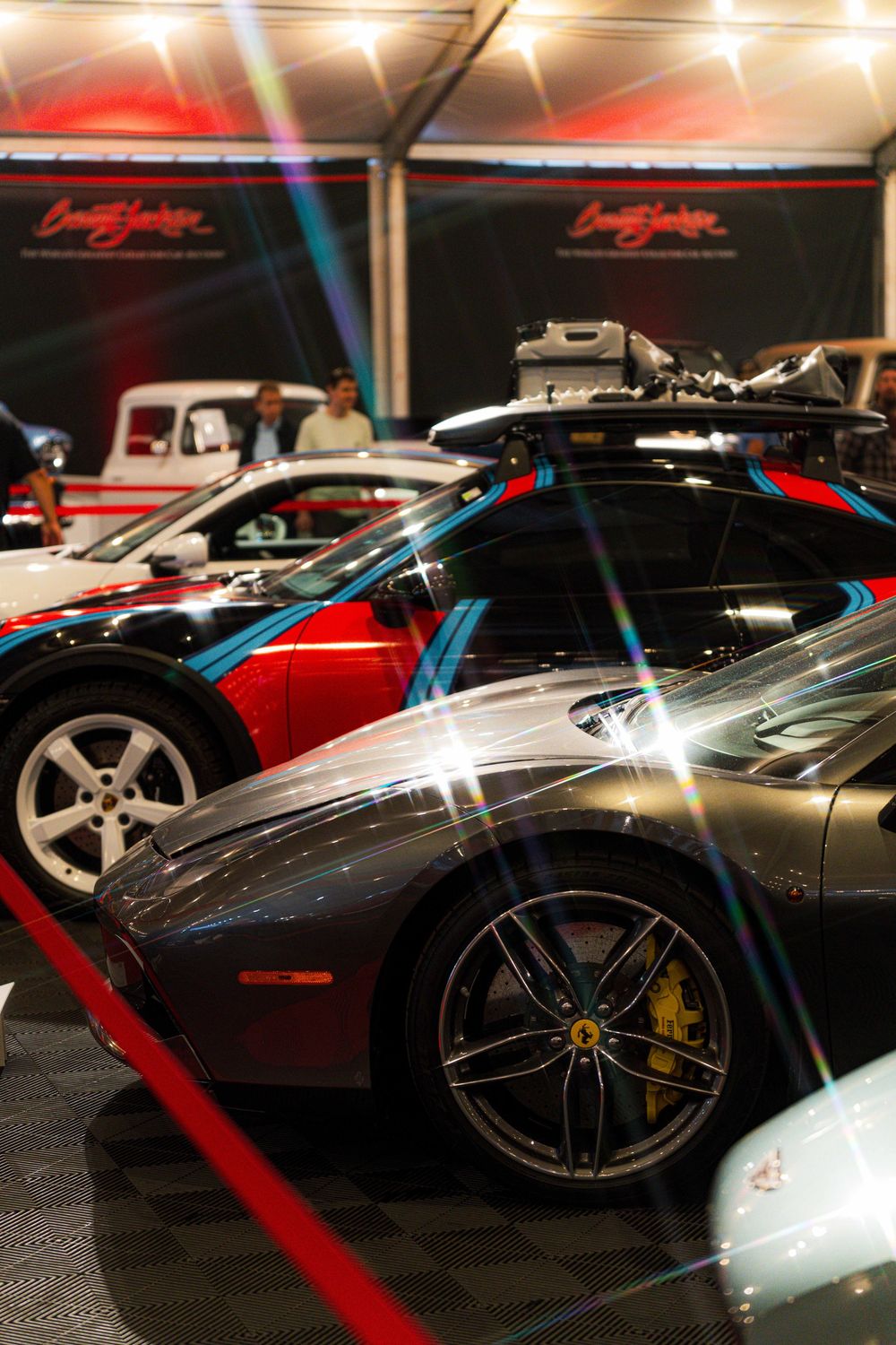 Collection of exotic sports cars including Ferrari and Lamborghini models displayed at an indoor auto show.