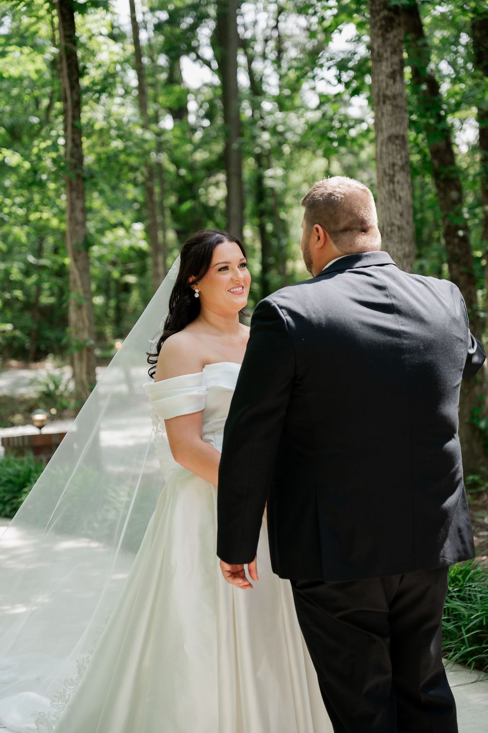 A couple shares tender moments during their outdoor wedding first look.