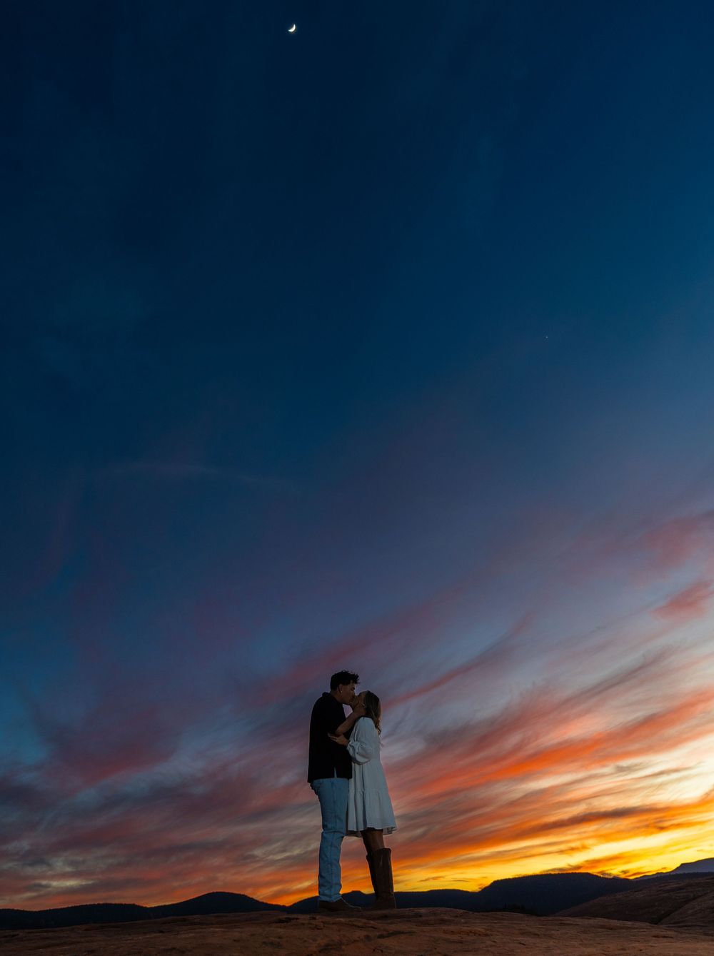 Dramatic sunset silhouettes against deep blue sky with vibrant orange clouds on horizon.