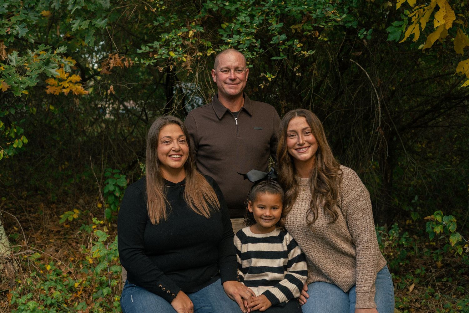 A family posing and smiling for the camera at their annual family photo session in Flint, Michigan.