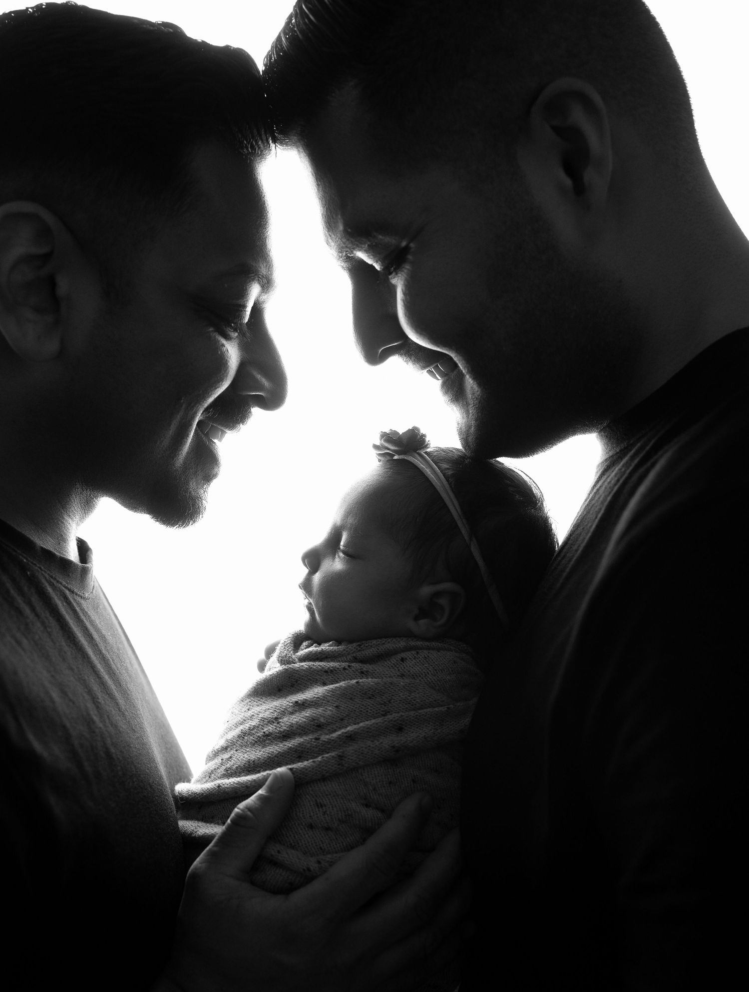 A series of black and white silhouettes showing an intimate moment between two people in dramatic lighting.