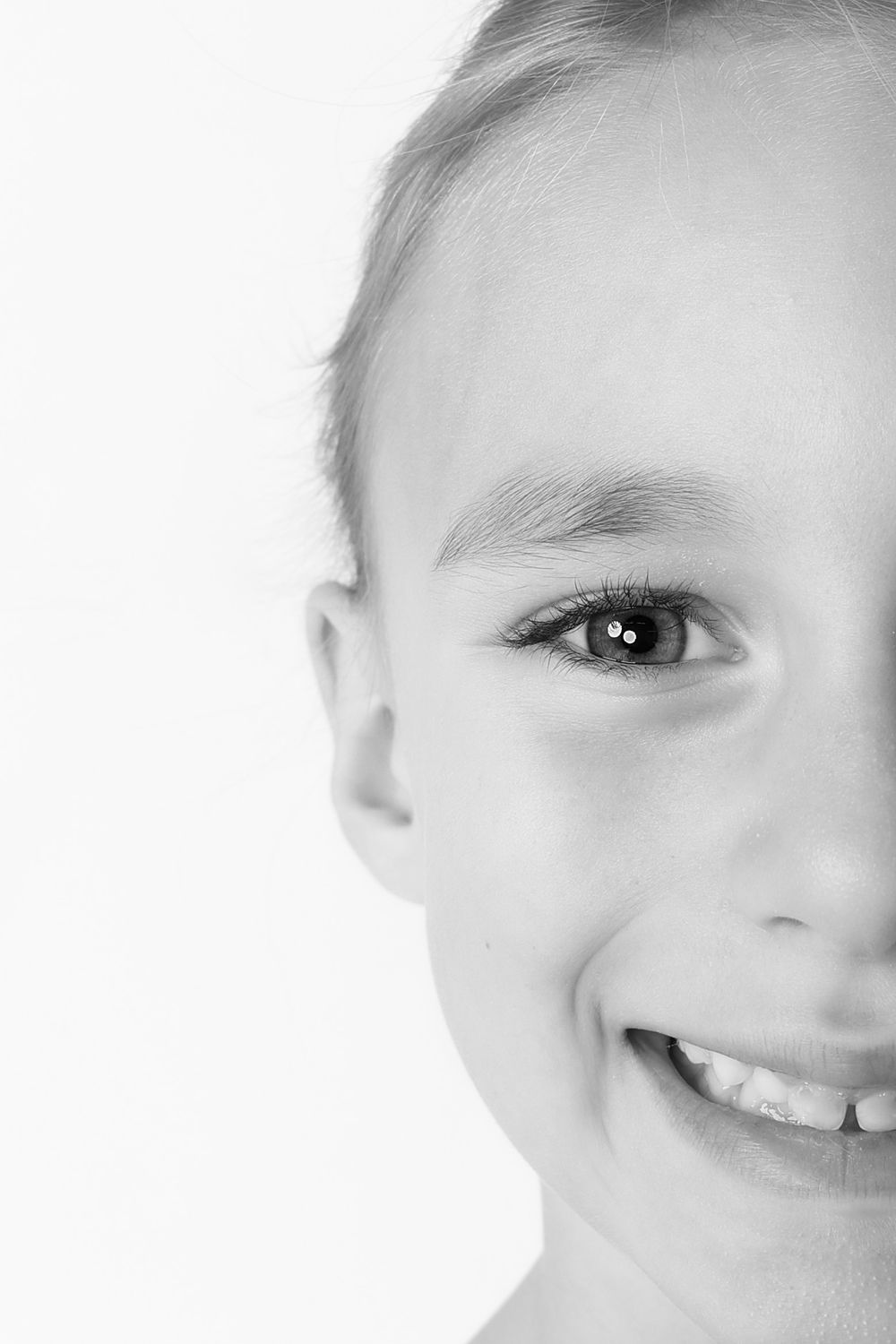 A close-up portrait series showing different cropped views of a smiling child's face against a white background.