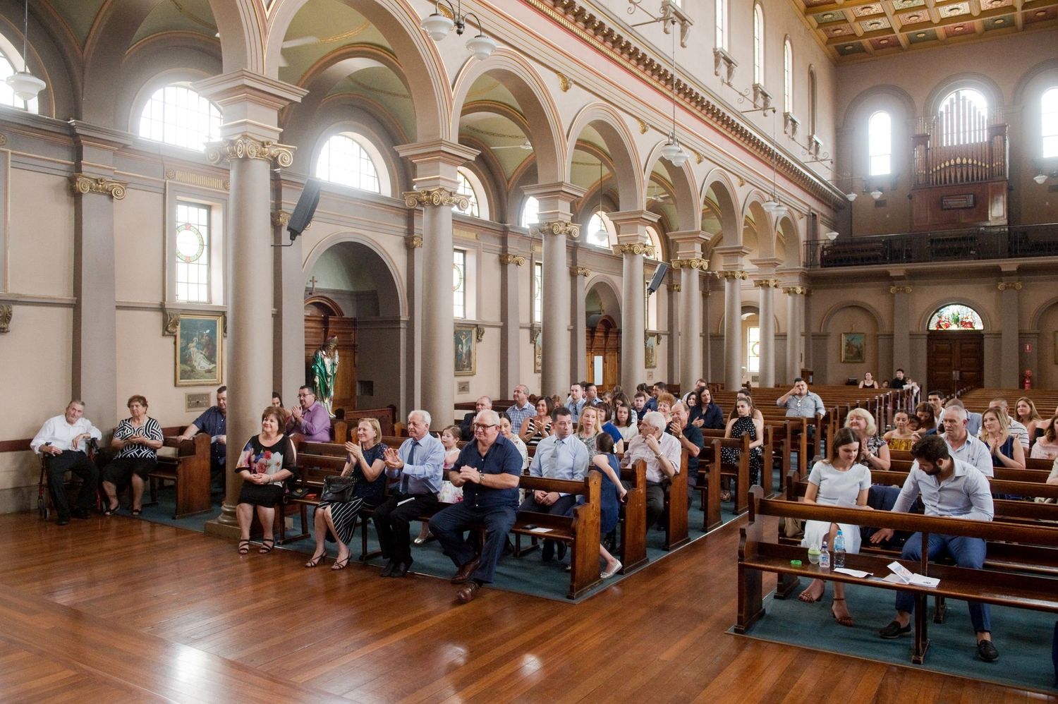 Panoramic view of church interior during baptismal service with congregation seated.