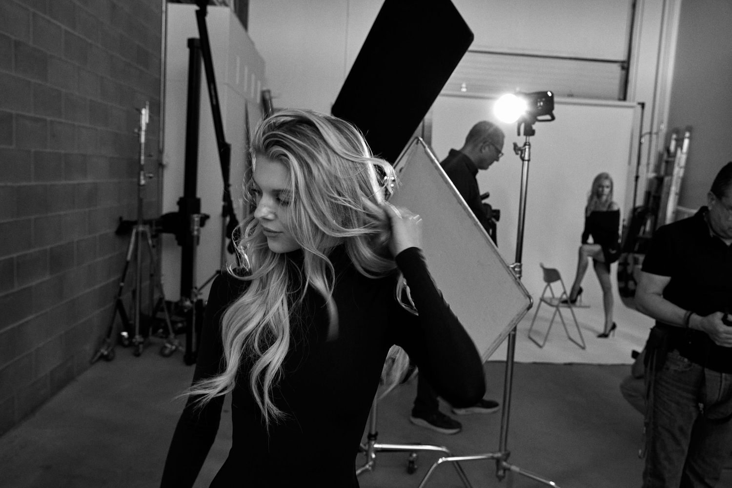 Behind-the-scenes photo shoot setup in a studio with lighting equipment.