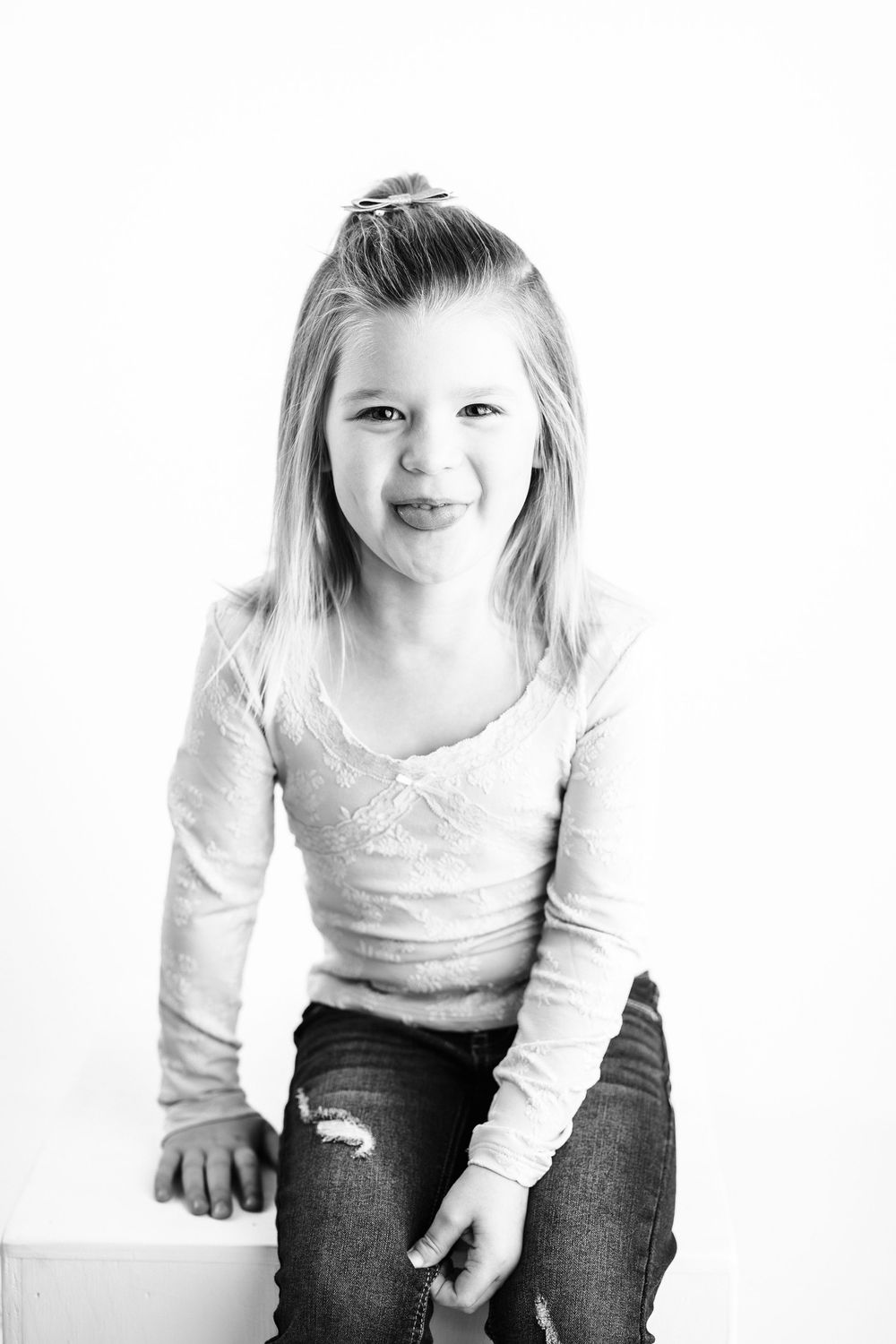 A series of candid black and white photos showing a child in casual attire against a white backdrop.