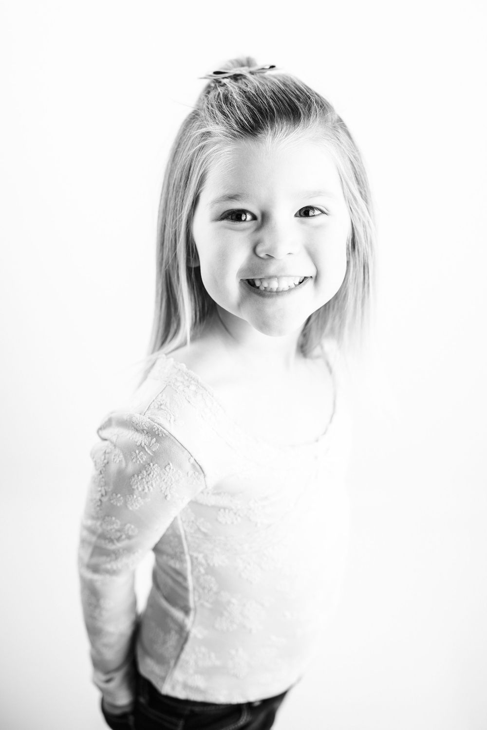 A series of four black and white portraits showing a young child's expressions ranging from pensive to joyful.