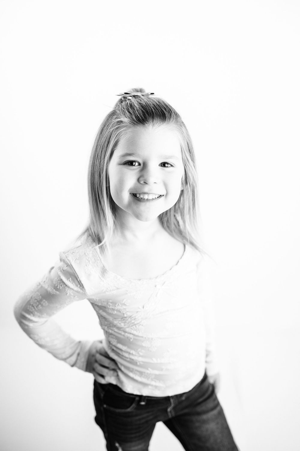 A sequence of four black and white portraits showing playful expressions and movement against a white background.