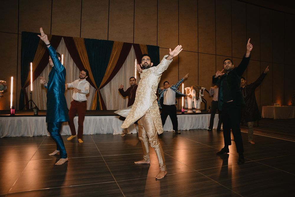 A groom in an embroidered sherwani leads a lively Bollywood dance performance at his wedding reception.at Sandia Resort and Casino