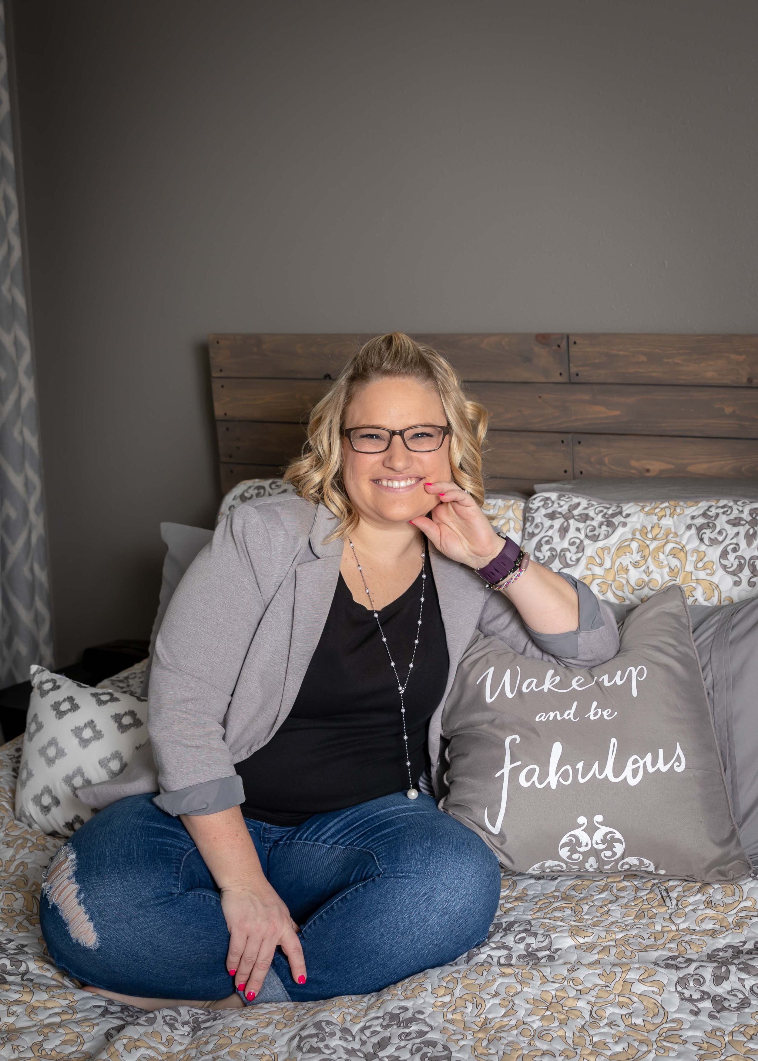 Casual lifestyle photos on a bed with decorative pillows and wooden headboard in a modern bedroom setting.