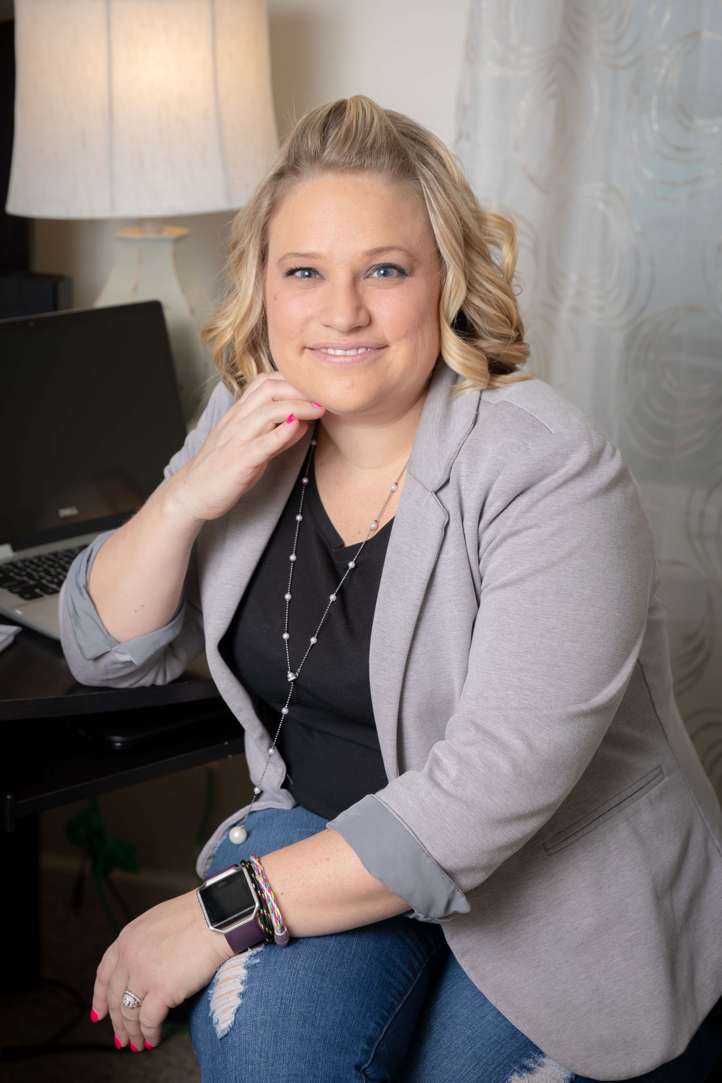 Professional headshots featuring casual business attire with a gray blazer and black top against a light background.