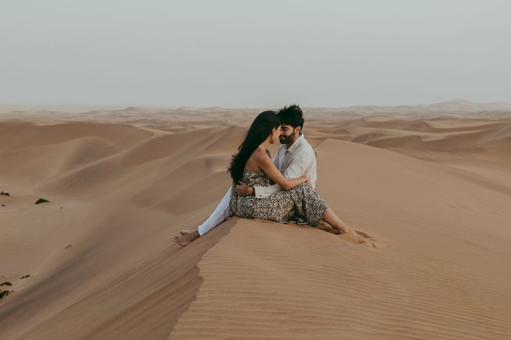 Couple holding hands and smiling during a photoshoot on Swakopmund sand dunes