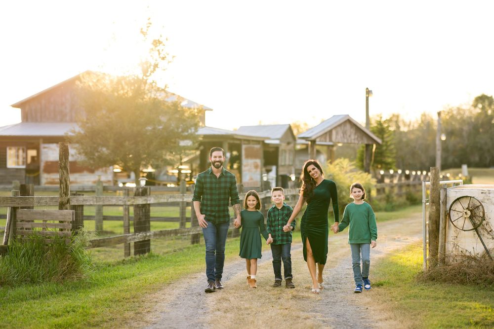 A group of people walk together along a path at sunset during a golden hour photo session.