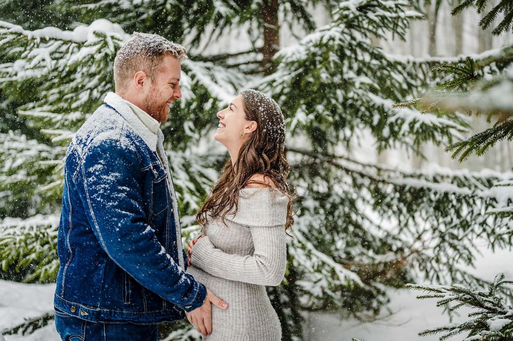 Winter engagement photos with snow-covered evergreen trees creating a magical backdrop.