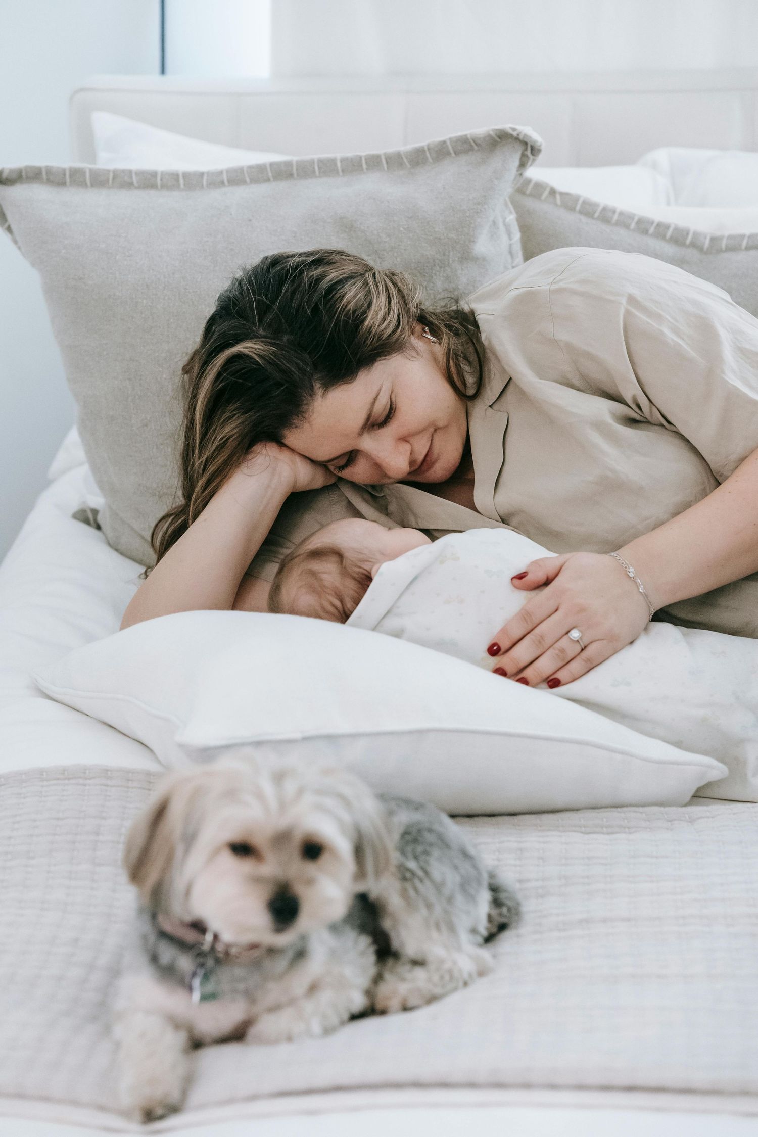 A tender moment shared between parent and baby in a white room with decorative elements in the background.