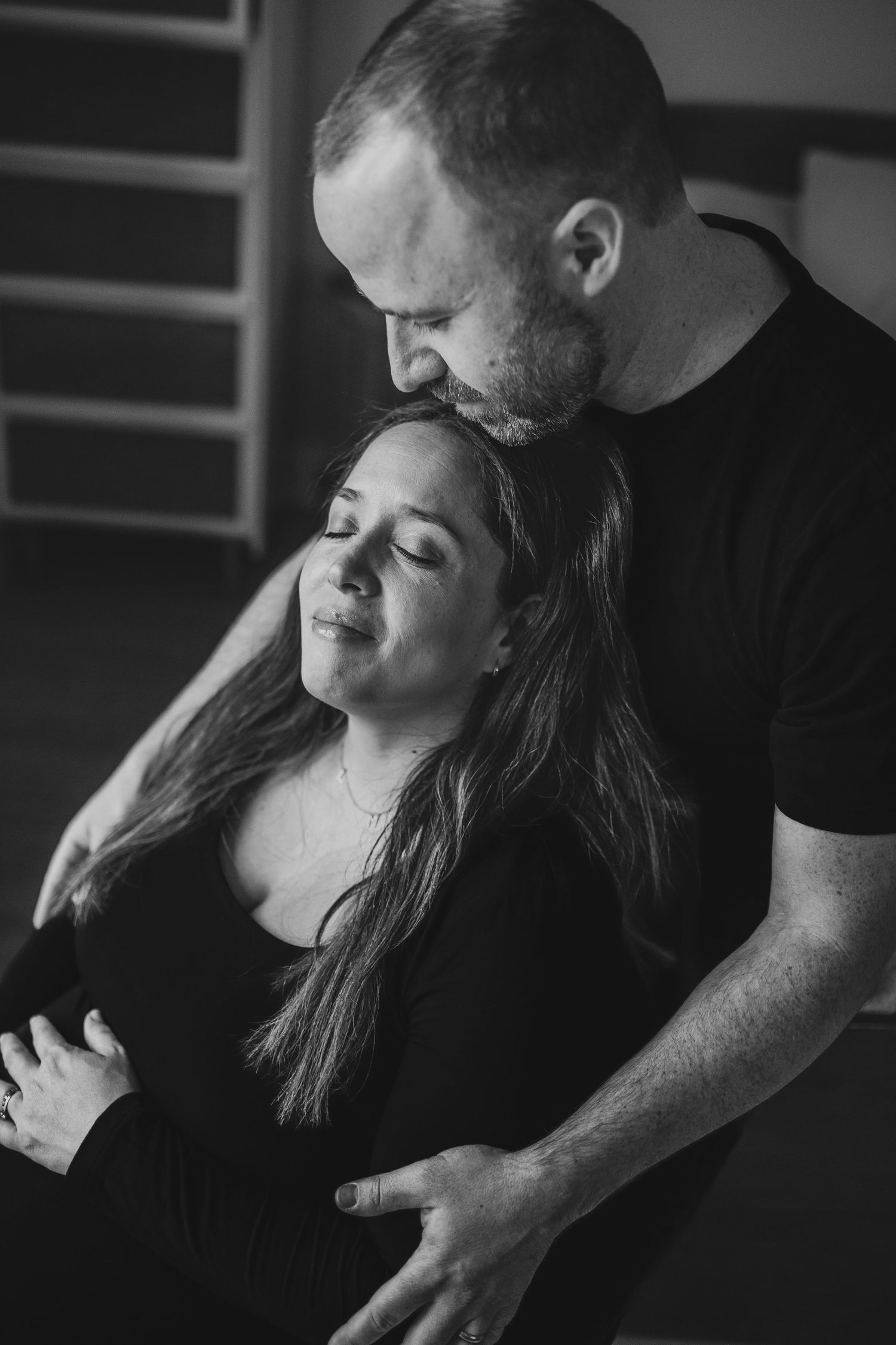A series of black and white romantic photos showing an intimate moment between a couple in dark clothing.