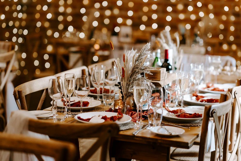 Elegant restaurant table settings with wine glasses and warm lighting create an intimate fine dining atmosphere.