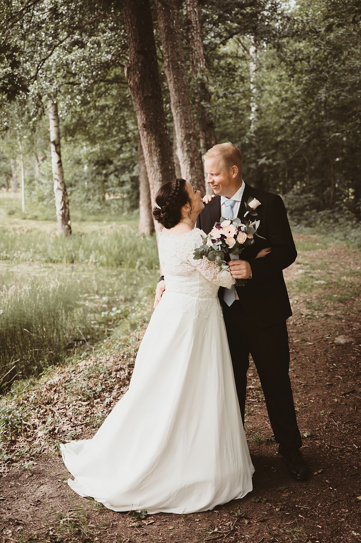 Bröllopsporträtt med grönska, brudpar fotograferade ute i den vackra naturen runt Medevi Brunn under deras bröllopsdag. Foto Lets Bloom