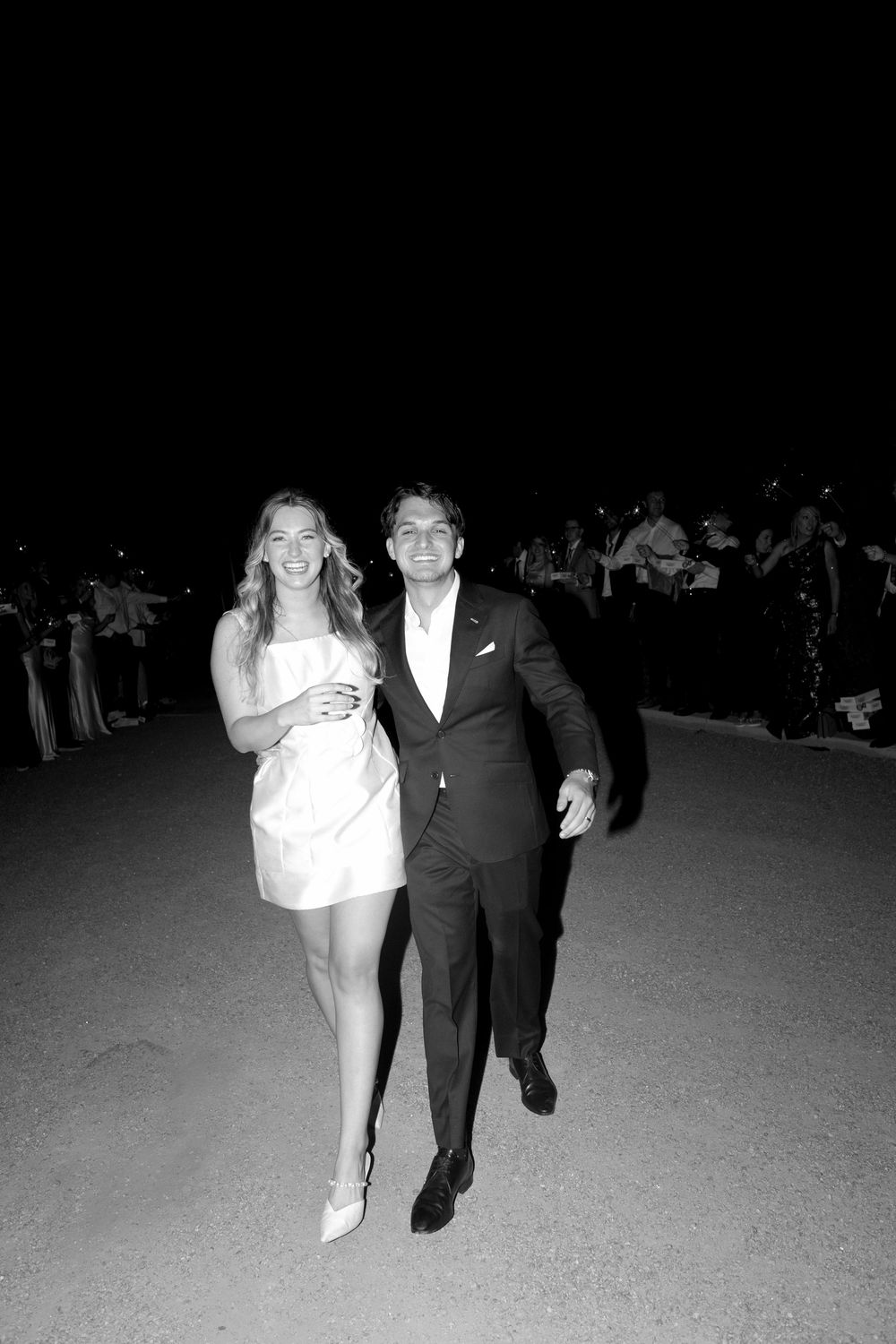 A sequence of black and white photos showing a couple walking together at night.