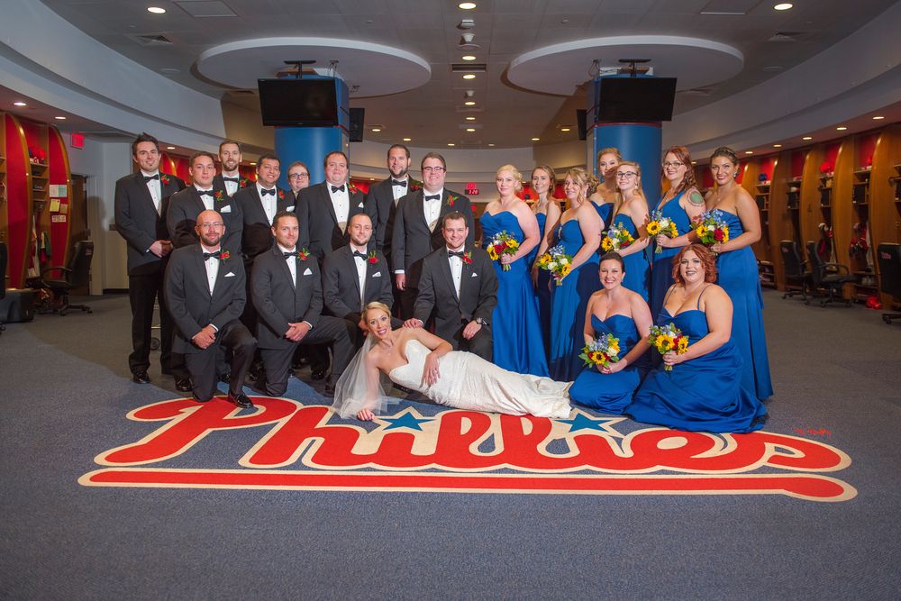 Wedding party poses together in formal attire in the clubhouse of the Philadelphia Phillies