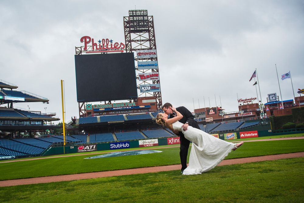 A bride in a white wedding dress poses for photos at Citizens Bank Park, home of the Philadelphia Phillies.
