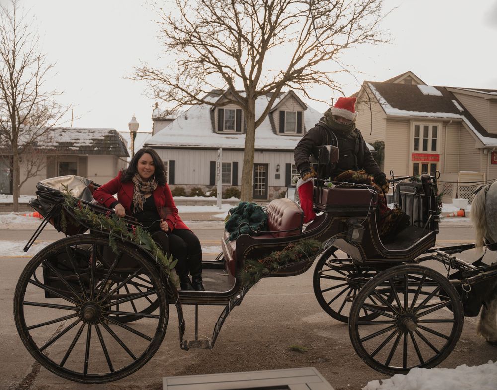 A line of horse-drawn carriages wait along a snowy street during winter festivities.