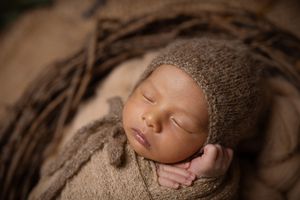 Series of peaceful sleeping newborn portraits on textured brown backdrop.