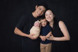 Studio portrait against dark background with soft lighting.