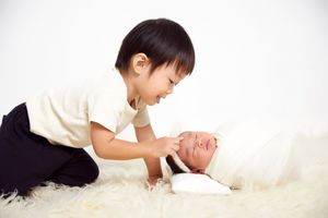 Artistic newborn photo series with baby on white fluffy backdrop.
