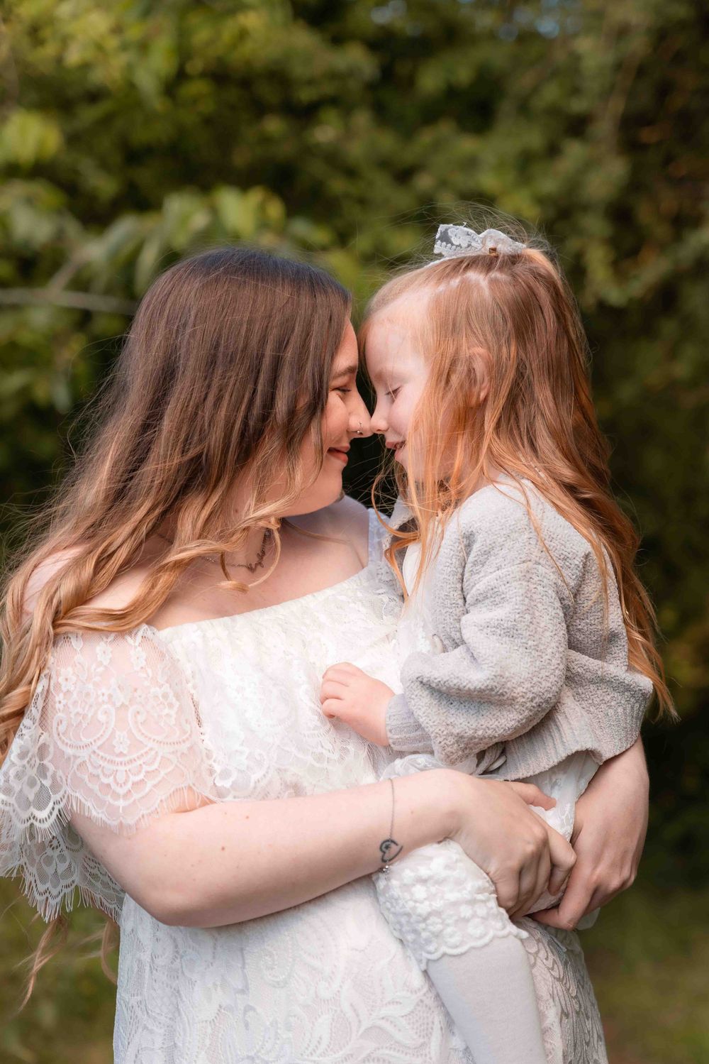 A series of intimate outdoor portraits showing tender embraces between two people in white and gray clothing.