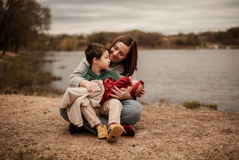 A couple shares tender moments together by a lake during an autumn photoshoot session.