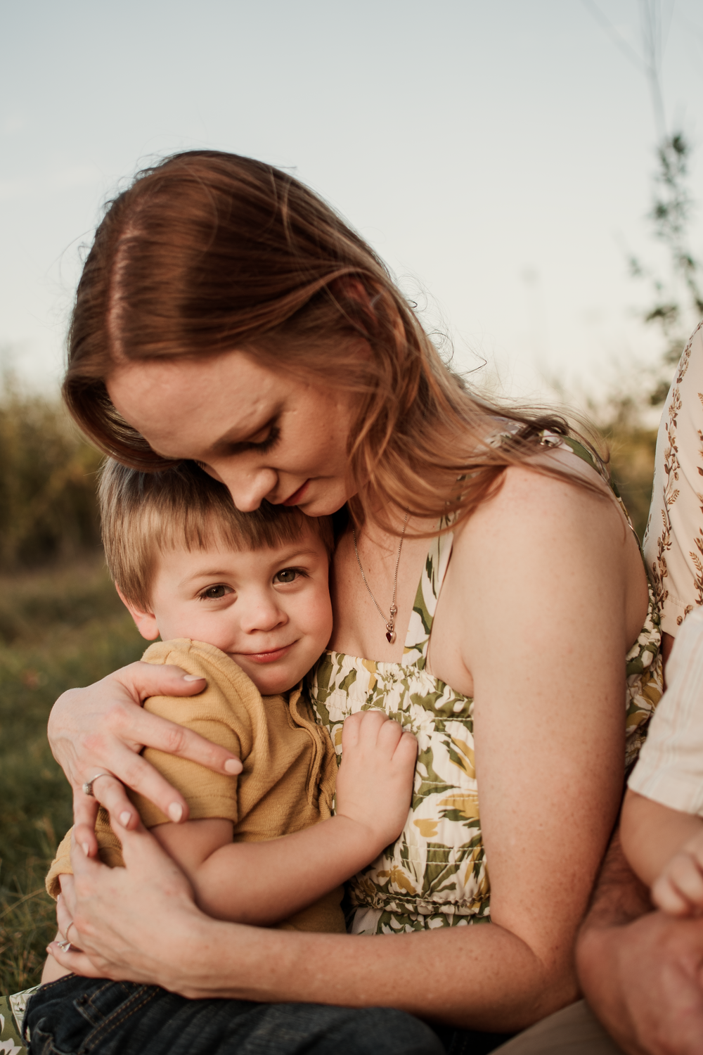 A tender moment captured in a series of warm outdoor photos showing a mother embracing her young child at sunset.